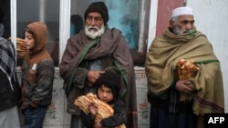 کابل کی ایک بیکری کے سامنے کھڑے امداد کے ضرورتمند افراد۔ 18 جنوری، 2022ء (فائل فوٹو)